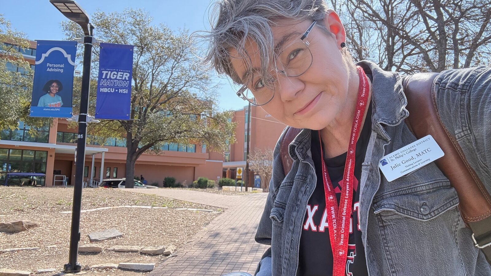 Julie Good on St. Philip's College campus with a Tiger Nation banner in the background