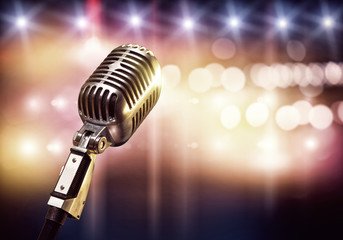 A gold microphone against stage lights